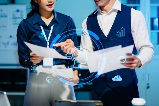 Deux collaborateurs analysent des documents imprimés au milieu d'une interface circulaire holographique représentant un profil de robot doté d'une IA.